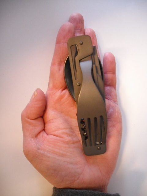 Papagayo Edelstahl Faltbesteck mit 6 Funktionen v. Baladeo Eine Hand hält ein kleines Edelstahl Faltbesteck mit mehreren Funktionen.
